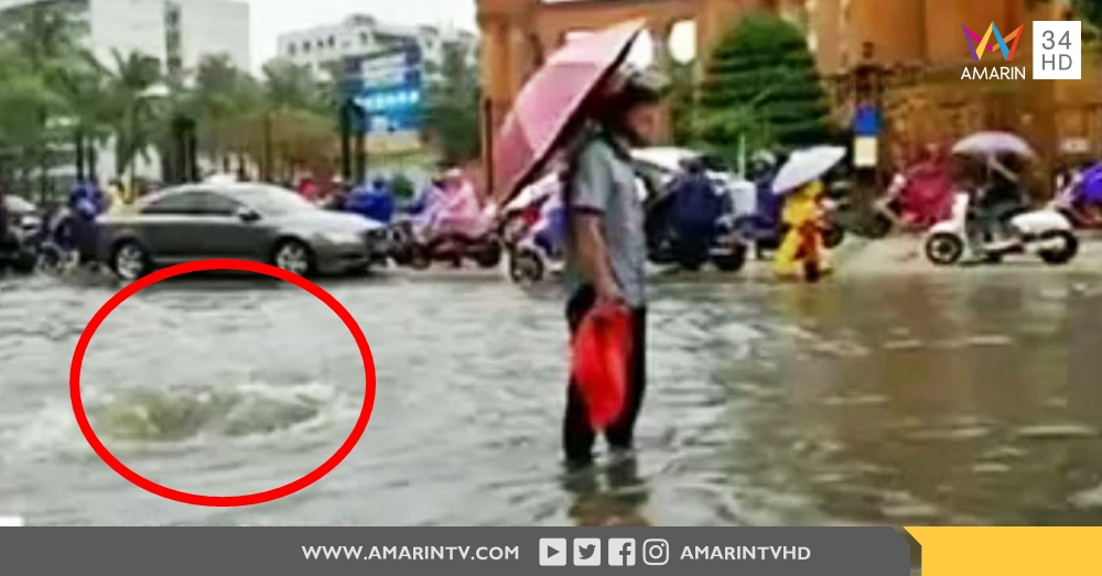 คนดีที่โลกรอ! ชายจีนยืนแช่น้ำท่วม ถือร่มกลางสายฝน เตือนคนเดินผ่านไปมาให้ระวังตกท่อ