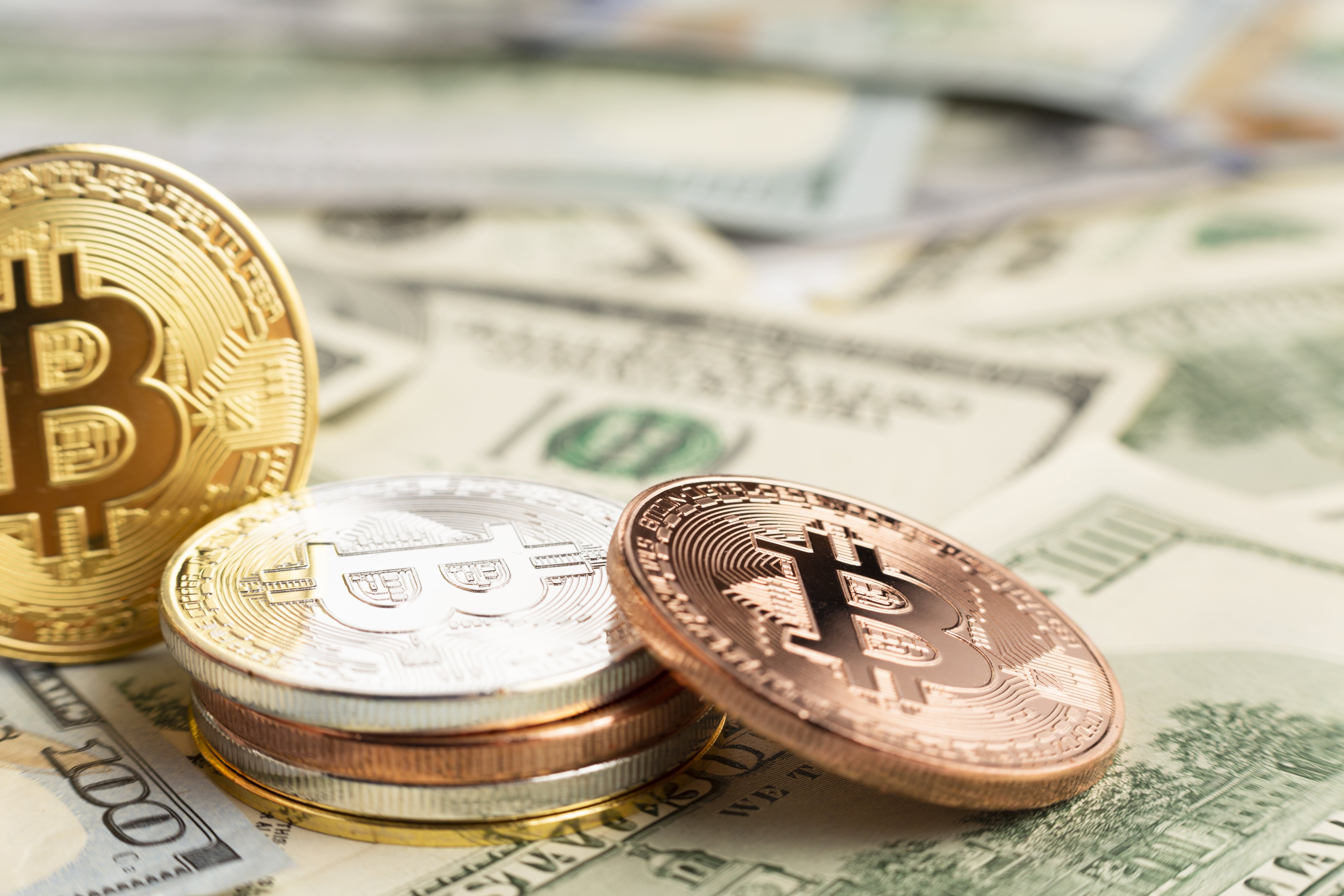 bitcoin-pile-top-dolar-bills